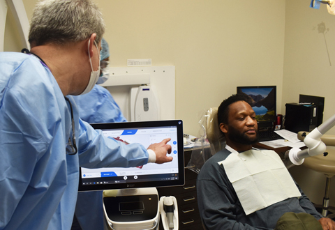 Dr. Casey Bloom, Birmingham VA Health Care System dentist and CEREC CAD/CAM specialist, reviews a digital impression for James Evans, U.S. Marine Corps Veteran. (Photo by James Branch)